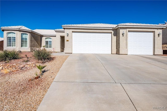 ranch-style home with concrete driveway, an attached garage, and stucco siding