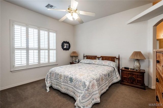 bedroom featuring baseboards, visible vents, arched walkways, ceiling fan, and dark carpet