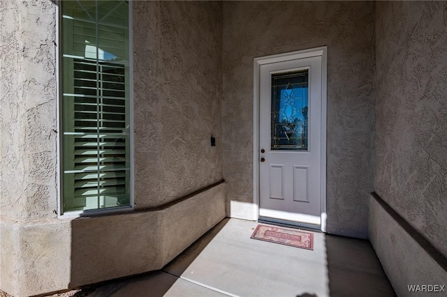 doorway to property featuring stucco siding