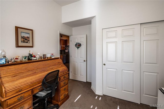 office area featuring dark colored carpet and baseboards