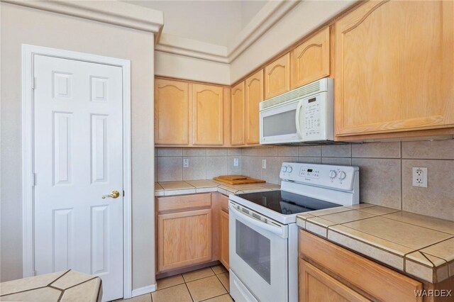 kitchen with white appliances, light brown cabinets, tile counters, and light tile patterned flooring