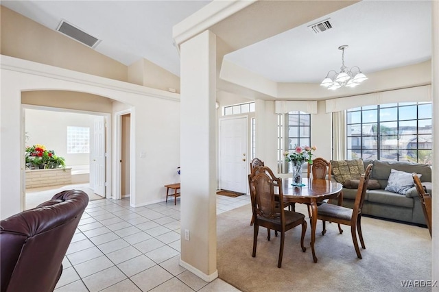 dining room featuring light tile patterned floors, lofted ceiling, visible vents, and an inviting chandelier