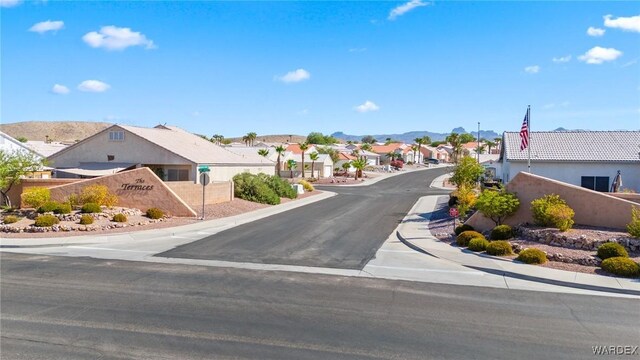 view of street with a residential view, curbs, sidewalks, and a mountain view