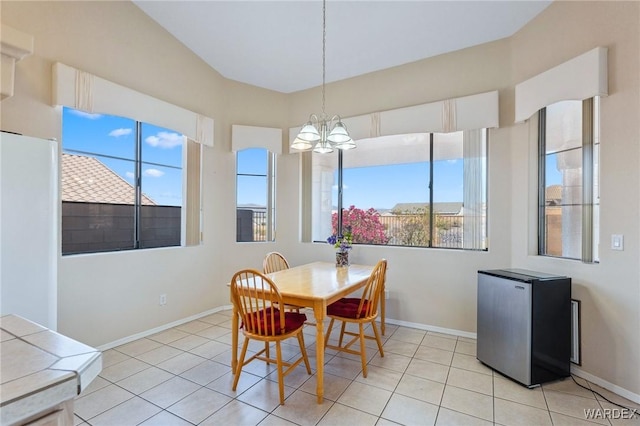 dining space featuring an inviting chandelier, baseboards, and light tile patterned flooring