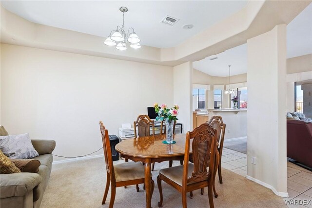 dining room featuring light colored carpet, visible vents, a notable chandelier, and light tile patterned flooring