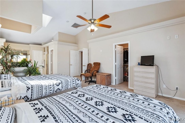 bedroom featuring vaulted ceiling, baseboards, a walk in closet, and light colored carpet