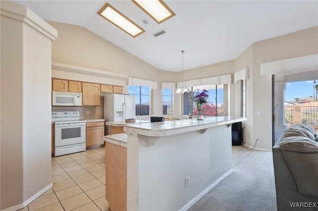 kitchen with white appliances, tile countertops, open floor plan, hanging light fixtures, and vaulted ceiling