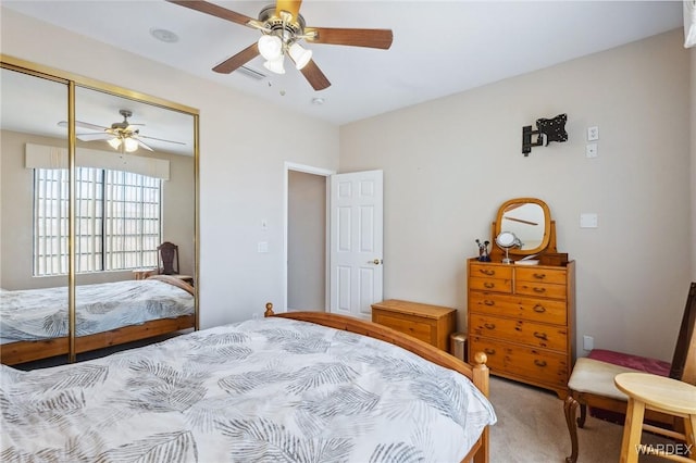 carpeted bedroom featuring a closet and ceiling fan