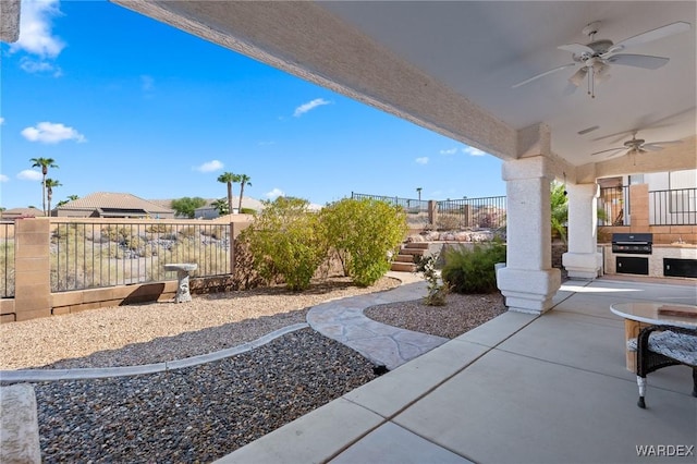 view of patio with exterior kitchen, a grill, ceiling fan, and a fenced backyard