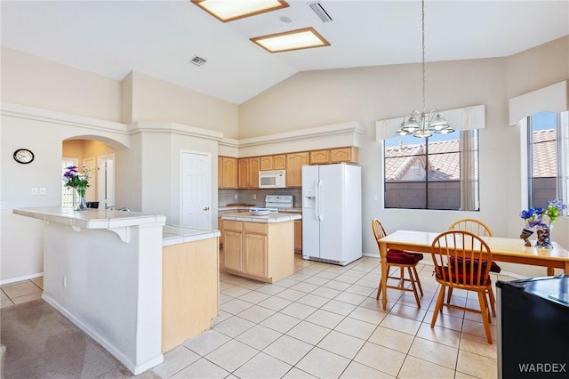 kitchen featuring light tile patterned floors, white appliances, visible vents, a center island, and pendant lighting