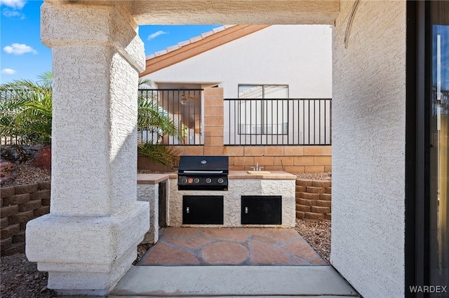 view of patio with exterior kitchen, a grill, and a sink