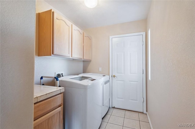 laundry room with cabinet space, independent washer and dryer, and light tile patterned floors