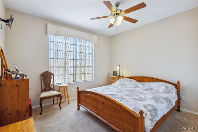 bedroom with a ceiling fan, light colored carpet, and baseboards