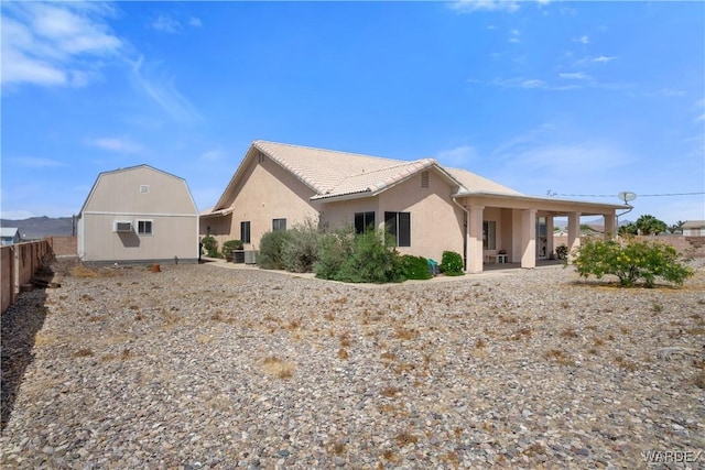 5790 S Gazelle Dr, Fort Mohave, AZ 86426 - back of house with a patio area, a tile roof, fence, stucco siding, and an outbuilding