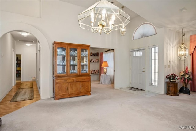 5790 S Gazelle Dr, Fort Mohave, AZ 86426 - carpeted entryway featuring arched walkways, a notable chandelier, and a high ceiling