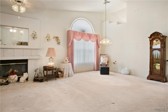 5790 S Gazelle Dr, Fort Mohave, AZ 86426 - sitting room with a tiled fireplace, carpet floors, an inviting chandelier, and a towering ceiling