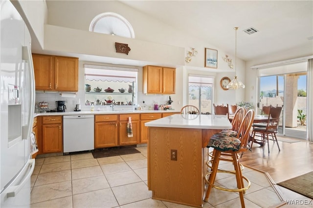 5790 S Gazelle Dr, Fort Mohave, AZ 86426 - kitchen with visible vents, light countertops, a breakfast bar, white appliances, and a kitchen island