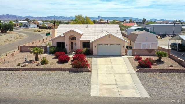 5790 S Gazelle Dr, Fort Mohave, AZ 86426 - view of front of home with a tiled roof, a garage, stucco siding, a mountain view, and driveway