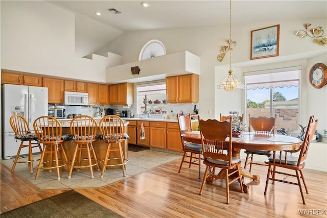 5790 S Gazelle Dr, Fort Mohave, AZ 86426 - dining room featuring a chandelier, high vaulted ceiling, light wood-style floors, and visible vents