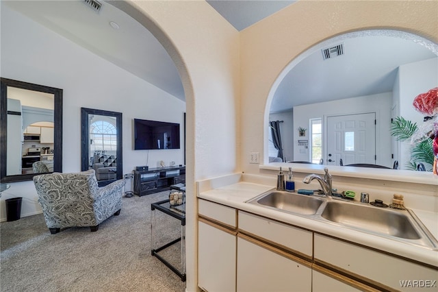 kitchen with light carpet, visible vents, light countertops, stainless steel stove, and a sink