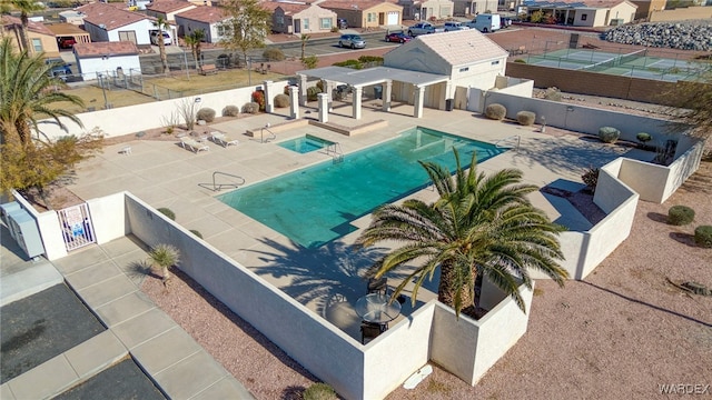 pool featuring a patio, fence, and a residential view