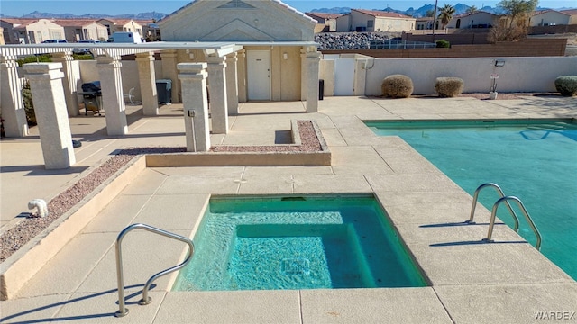 view of swimming pool featuring a fenced in pool, a patio, fence, an in ground hot tub, and a residential view