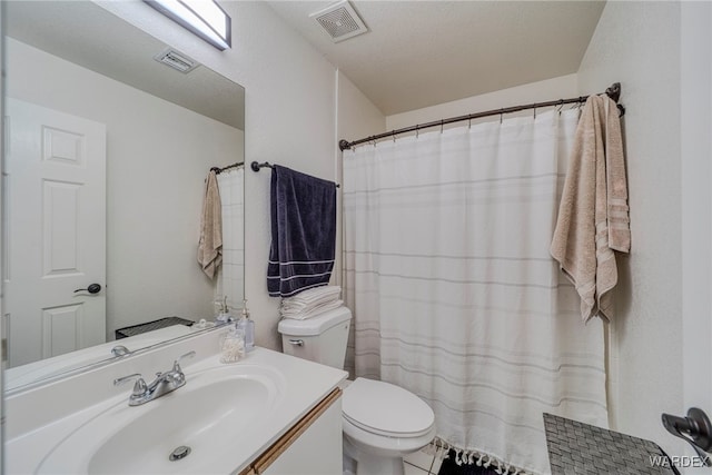 bathroom featuring toilet, vanity, and visible vents