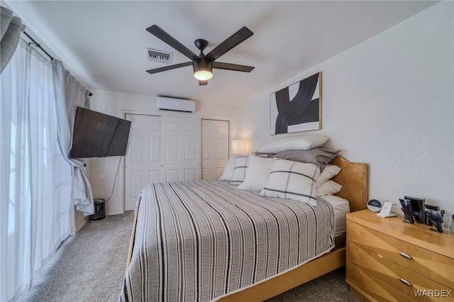 carpeted bedroom with ceiling fan, a closet, a wall unit AC, and visible vents