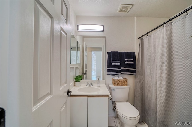 bathroom featuring toilet, a textured ceiling, vanity, and visible vents