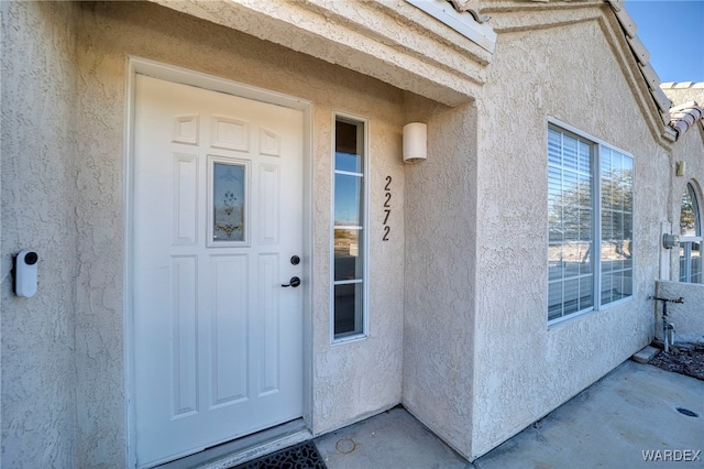 doorway to property featuring stucco siding