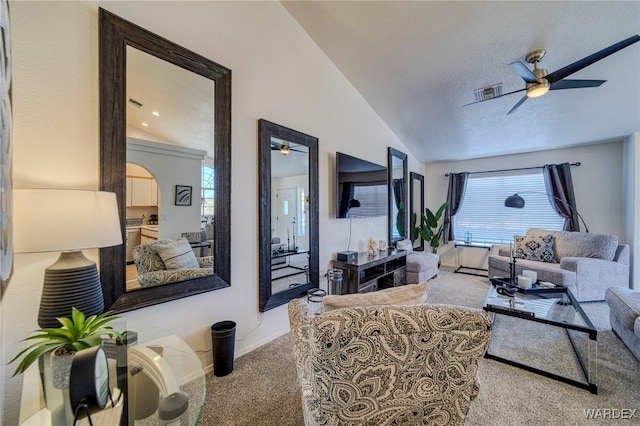 living room featuring vaulted ceiling, ceiling fan, carpet, and visible vents