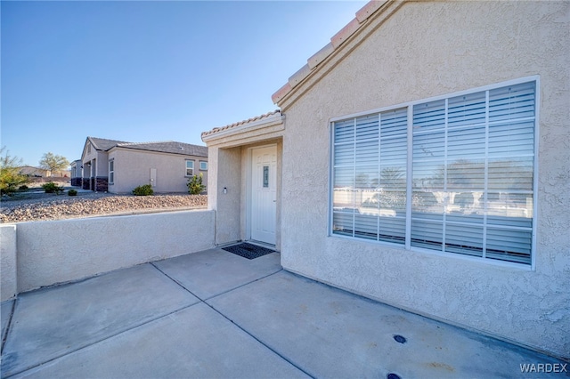 doorway to property with a patio and stucco siding