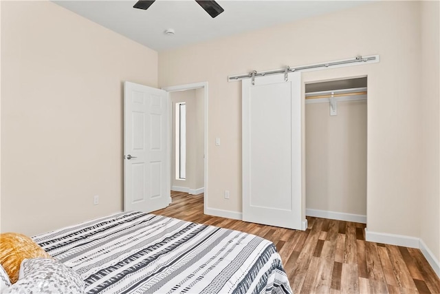 6183 S Lago Grande Dr, Fort Mohave, AZ 86426 - unfurnished bedroom featuring wood finished floors, baseboards, a closet, ceiling fan, and a barn door