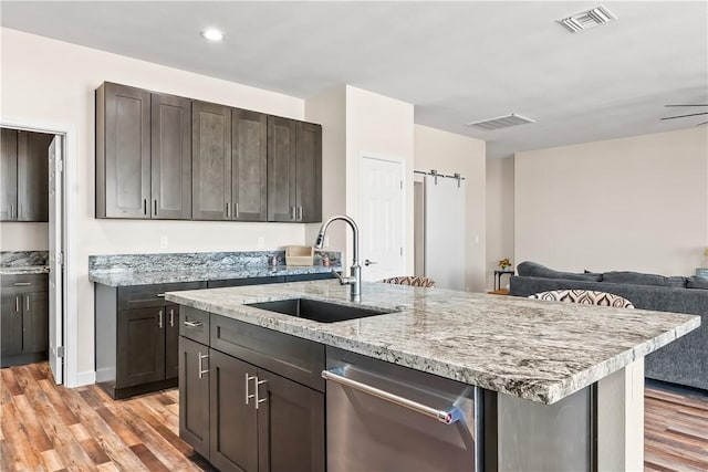 6183 S Lago Grande Dr, Fort Mohave, AZ 86426 - kitchen featuring a sink, stainless steel dishwasher, light wood-type flooring, open floor plan, and light stone countertops