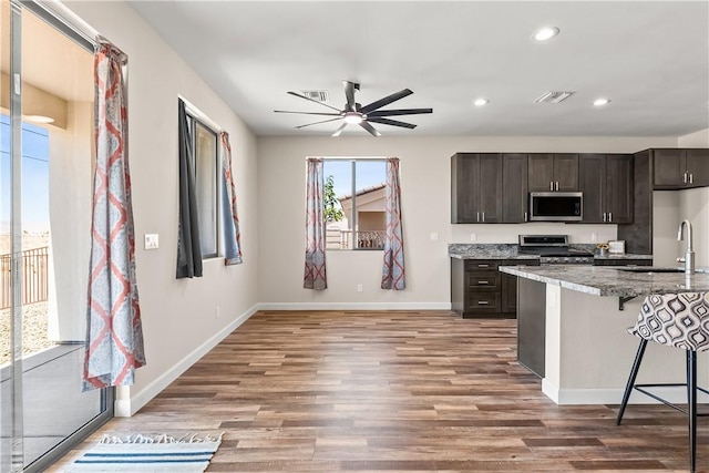 6183 S Lago Grande Dr, Fort Mohave, AZ 86426 - kitchen featuring stainless steel appliances, a ceiling fan, baseboards, a breakfast bar, and recessed lighting