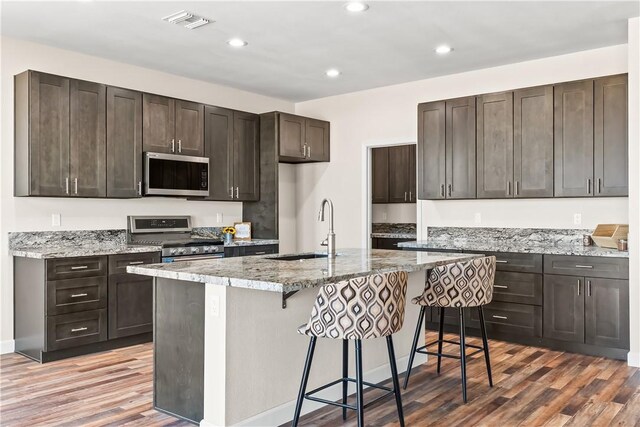 6183 S Lago Grande Dr, Fort Mohave, AZ 86426 - kitchen featuring stainless steel appliances, a sink, wood finished floors, recessed lighting, and a kitchen breakfast bar