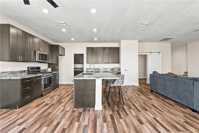 6183 S Lago Grande Dr, Fort Mohave, AZ 86426 - kitchen with appliances with stainless steel finishes, open floor plan, a breakfast bar area, wood finished floors, and a sink