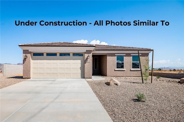 10651 S Black Mesa Dr, Yucca, AZ 86438 - view of front facade with concrete driveway, an attached garage, and stucco siding