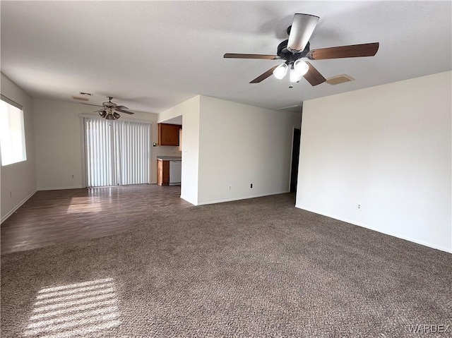 unfurnished living room with a ceiling fan, visible vents, dark carpet, and baseboards