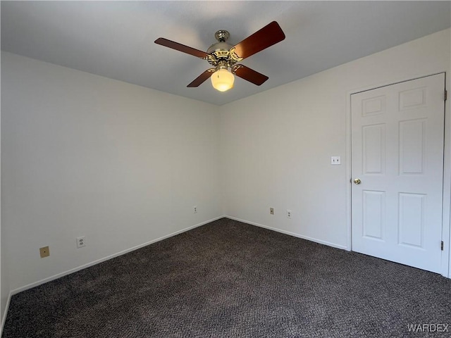 empty room featuring dark carpet, baseboards, and ceiling fan