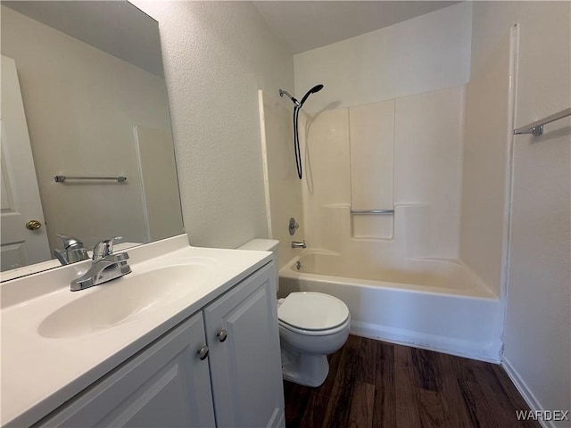 bathroom featuring toilet, bathing tub / shower combination, wood finished floors, and vanity