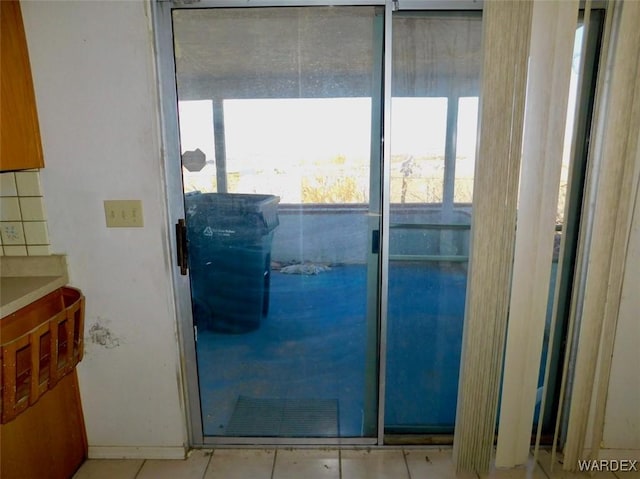 doorway to outside with light tile patterned floors