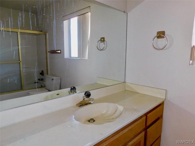 bathroom featuring shower / bath combination with glass door, vanity, and toilet