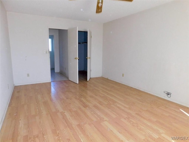 unfurnished room featuring light wood-type flooring and a ceiling fan