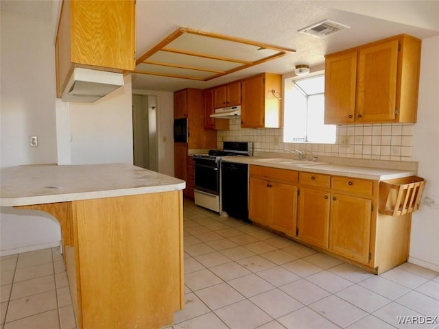 kitchen featuring white gas stove, under cabinet range hood, a sink, light countertops, and brown cabinets