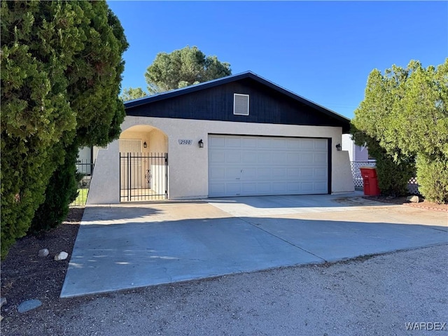 garage featuring fence, a gate, and concrete driveway