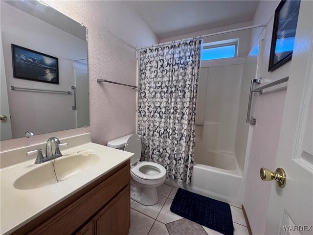 bathroom featuring shower / bath combo, toilet, a textured wall, vanity, and tile patterned flooring