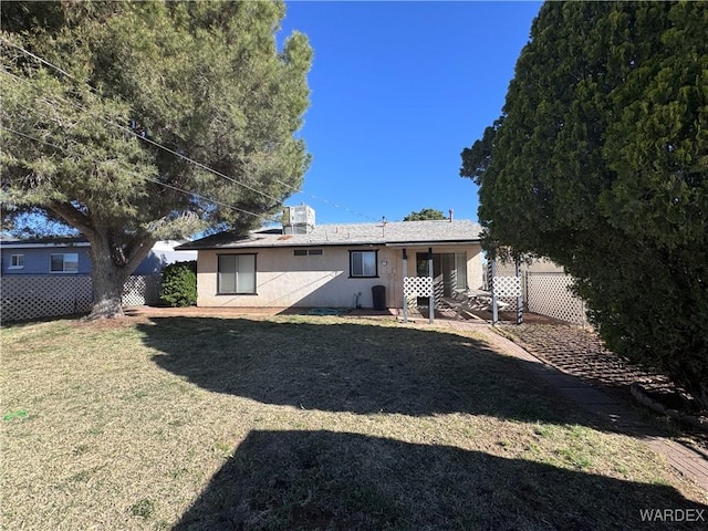 back of house featuring a patio, a yard, stucco siding, and fence