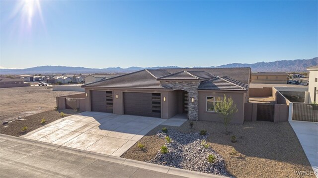 view of front of house featuring a garage, concrete driveway, a mountain view, and a tiled roof