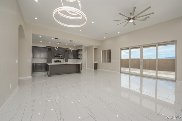 unfurnished living room featuring baseboards, marble finish floor, a ceiling fan, and recessed lighting